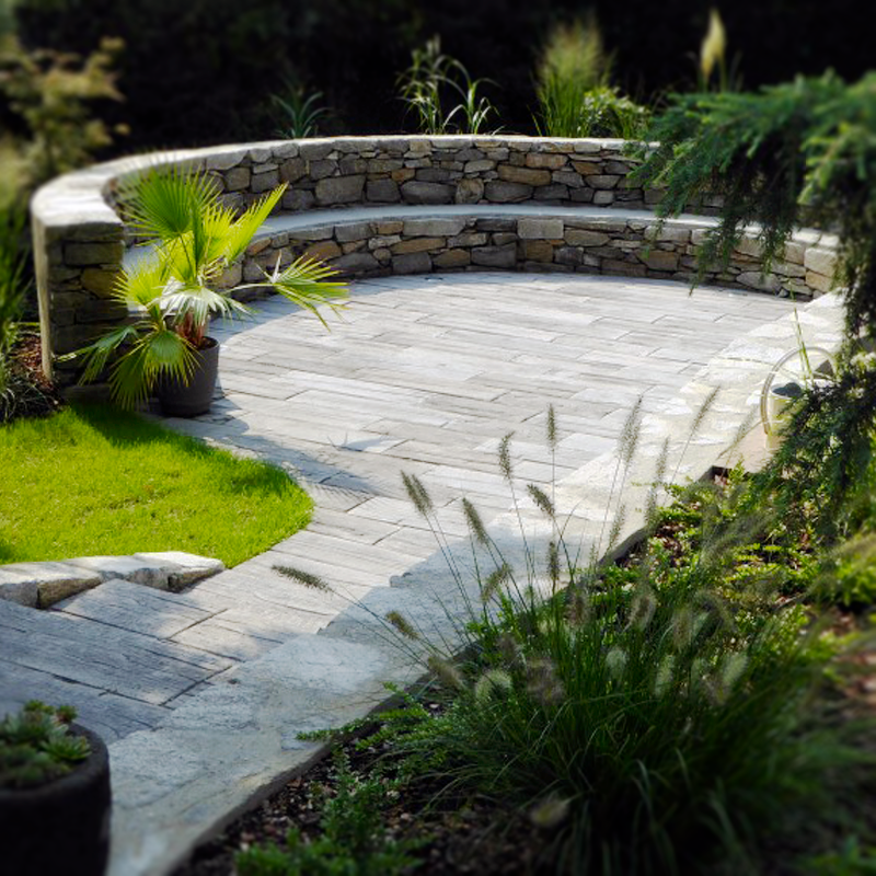 Dynamische Gartengestaltung Eder Steinmauer und Pflasterung Kombination aus Pflasterung und Natursteinmauer, harmonisch ins Gesamtbild integriert